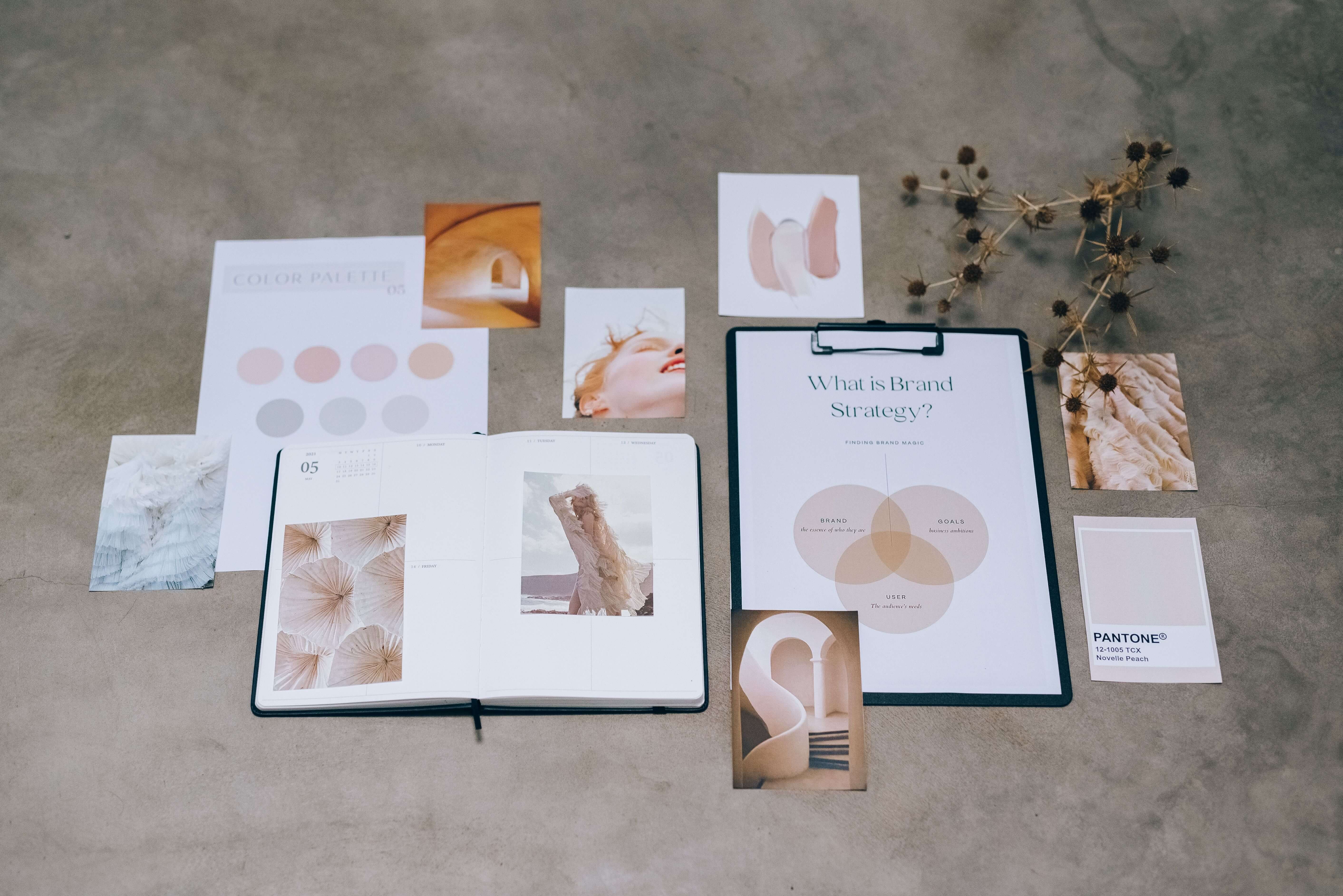 A designer laying out project work and a moodboard on a desk while curating a portfolio